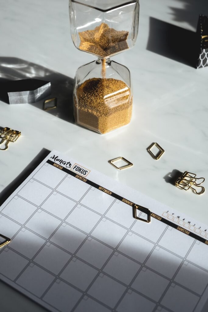 white calendar and golden hourglass
