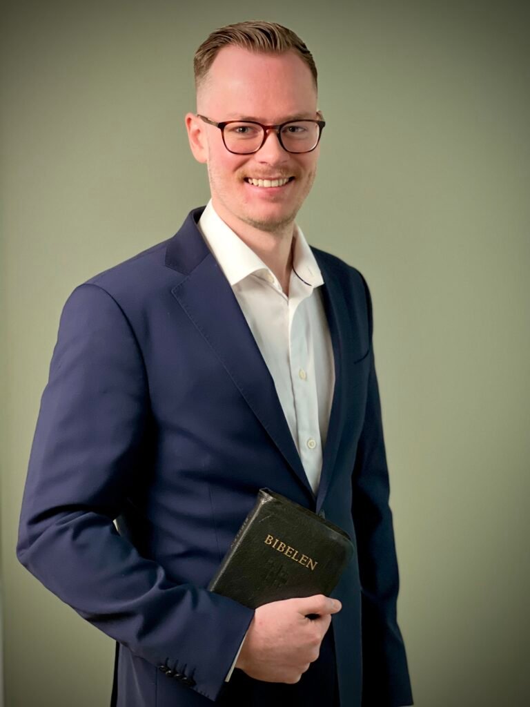 Founder of FaithElevate, holding a bible with a suit