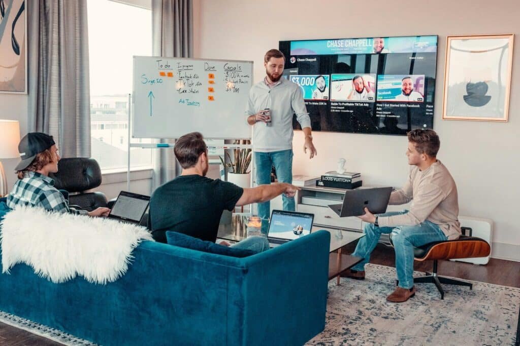 a group of people sitting around a living room. Group mastermind