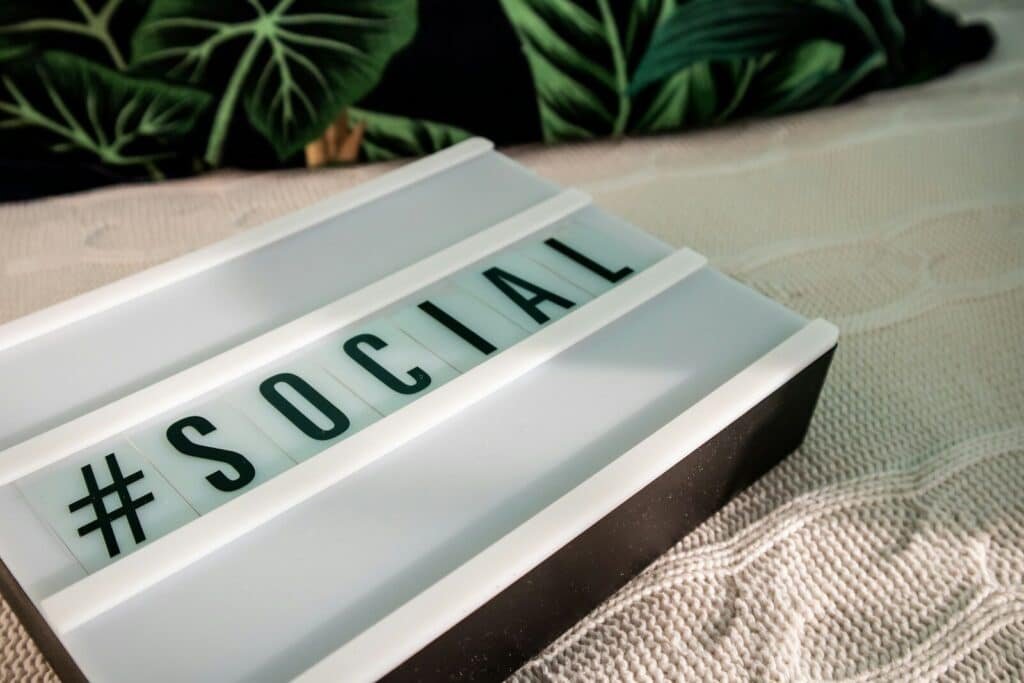 a close up of a sign with a plant in the background. Hashtag leverage